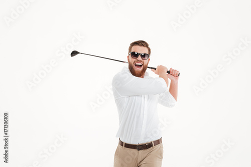 Young screaming emotional bearded man holding golfstick