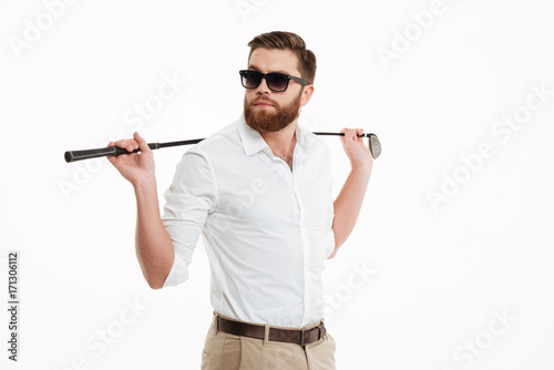 Young bearded man standing over white wall