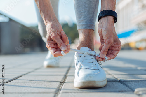 Close up of female hands tying shoelaces on sneakers