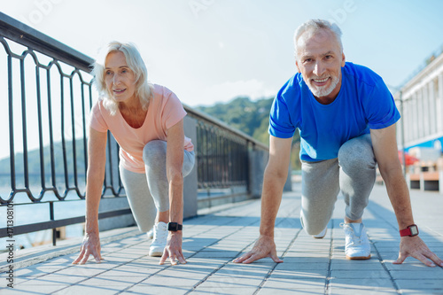 Upbeat elderly couple being about to start race