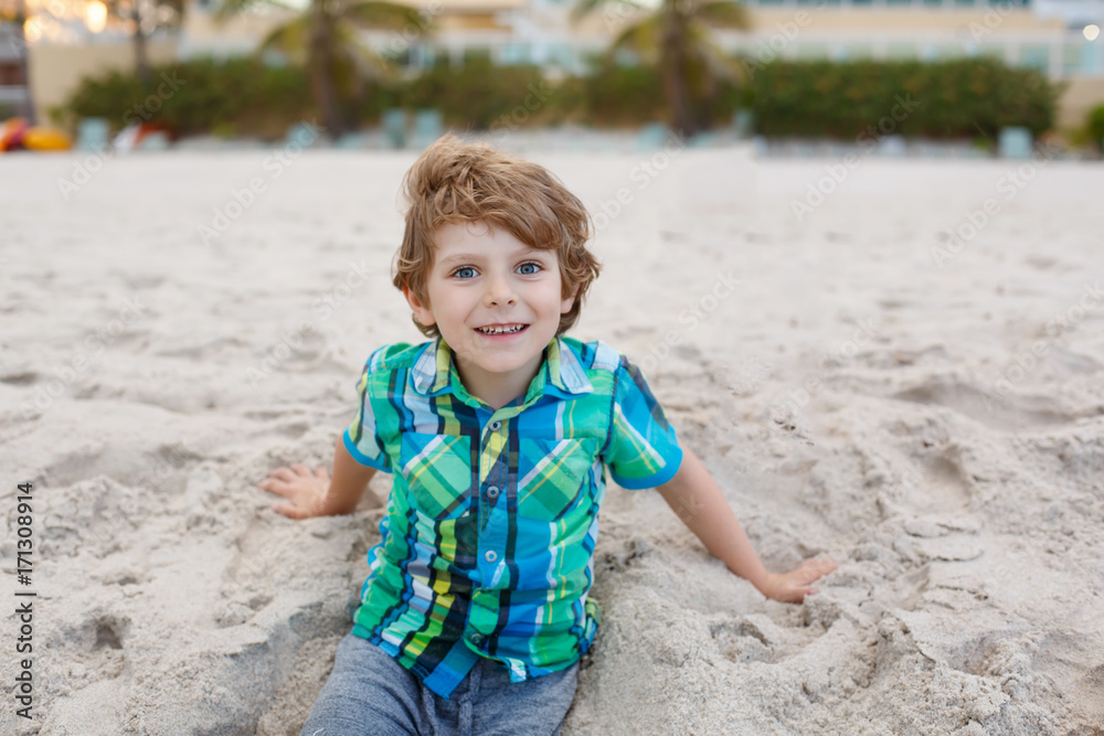 little kid boy running on the beach of ocean little kid boy running on the beach of ocean