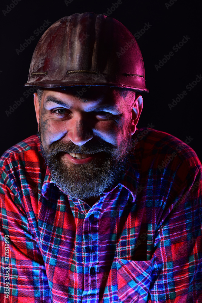 Worker with brutal image wears dirty helmet and plaid shirt Worker with brutal image wears dirty helmet and plaid shirt