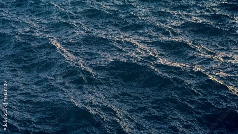 Fly over ocean water surface in evening time