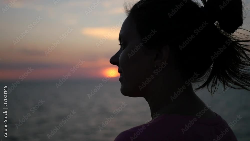 The girl admires the sunset at the sea, looks into the distance smiling. HD, 1920x1080. slow motion. The girl admires the sunset at the sea, looks into the distance smiling. HD, 1920x1080. slow motion.