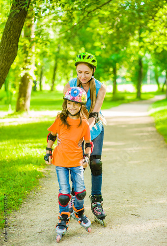 Mother teaches her daughter to ride roller skates