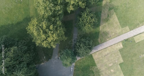 Aerial top down dolly view of a tree lined cycling path in a park in South London photo