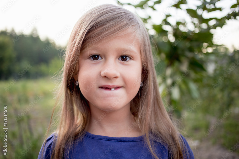 Young little girl without a front tooth in the countryside Young little girl without a front tooth in the countryside