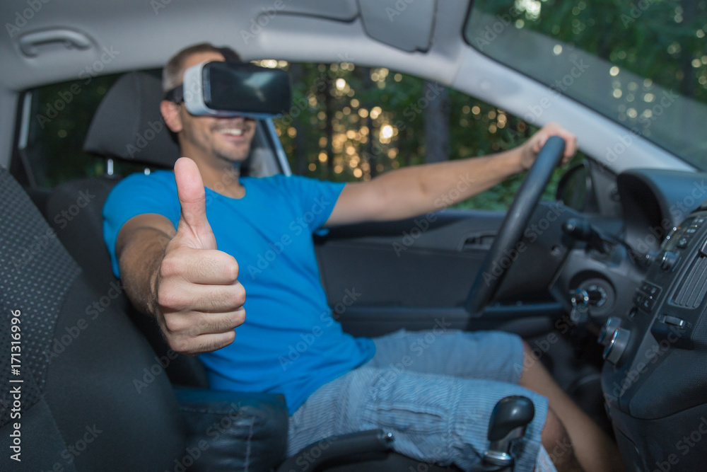 Man with virtual reality glasses sitting in car and showing thumbs up Man with virtual reality glasses sitting in car and showing thumbs up