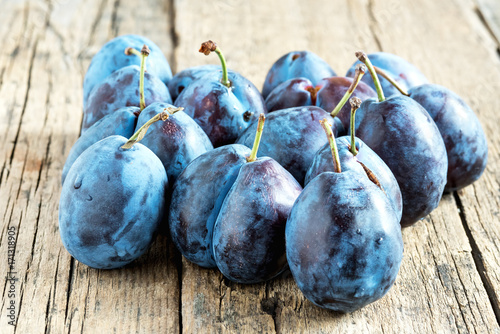 Group of sweet plums on wooden background