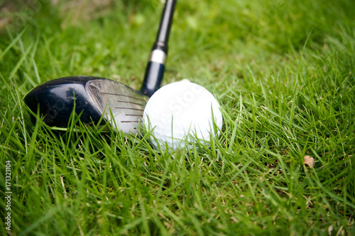 Golf ball and golf club on grass