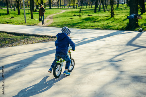 young boy riding strider bike