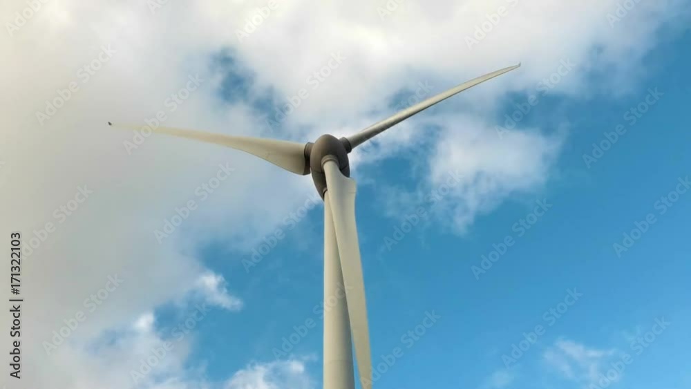 Spinning windmill on a cloudy day. Modern electric power production technology. Renewable energy sources concept. Environment friendly electricity production. Close up Spinning windmill on a cloudy day. Modern electric power production technology. Renewable energy sources concept. Environment friendly electricity production. Close up