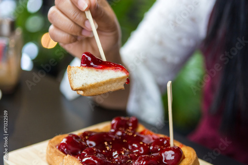 Eating trawberry jam toast on  wooden plate photo