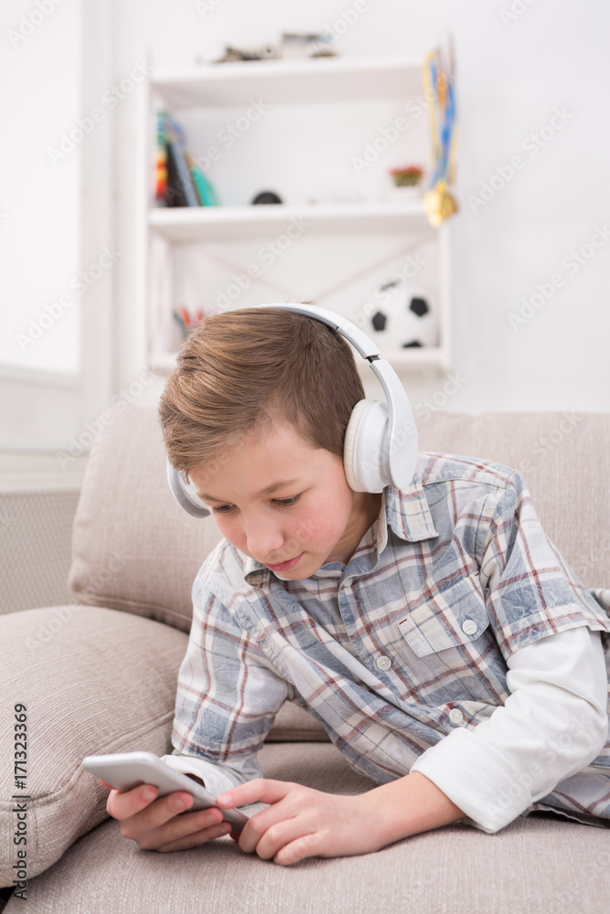 Teenager messaging online on smartphone in living room at home Teenager messaging online on smartphone in living room at home