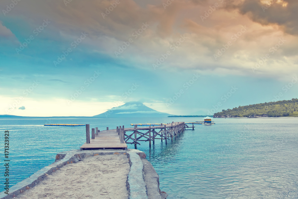 Panorama Wooden bridge at the sea at sunrise with background mountain