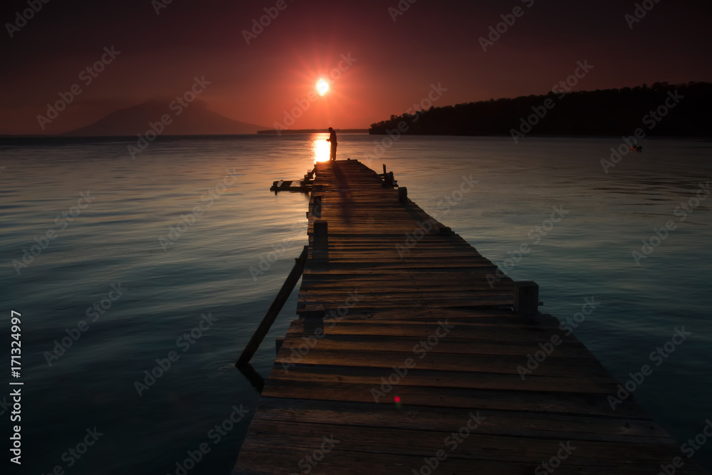 Landscape of wooden bridge in the port between sunsets
