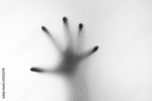 Shadow of hand the white frosted glass