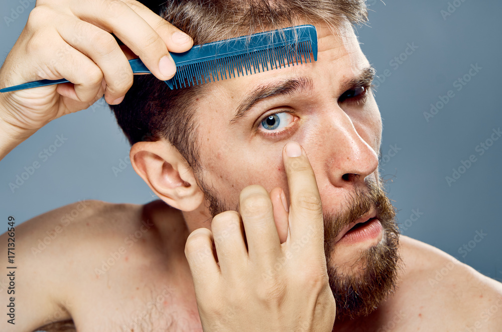 Obraz premium man combs his eyebrows, portrait, close-up