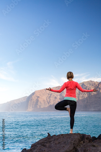 Woman meditating in yoga vrksasana tree pose