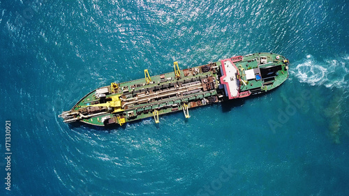 Suction Dredger ship working near the port - with mud, Pollution, brown Muddy water - aerial tip down shot photo