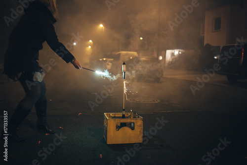 Frau zündet Feuerwerkskörper zu Silvester an