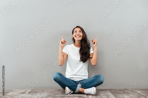 Happy cheerful asian woman sitting on the floor