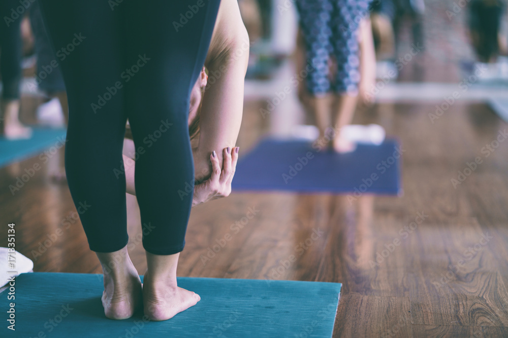 Group of asian young woman stretching and practices practicing during their yoga class in a gym. fitness, sport, training, yoga and people concept Group of asian young woman stretching and practices practicing during their yoga class in a gym. fitness, sport, training, yoga and people concept
