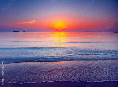 Beautiful tropical sunset in Krabi, Thailand. Dramatic and picturesque evening scene. Ocean waves and colorful cloudy sky and sun in the background. Nature landscape. Travel background. Bright colors © Goinyk