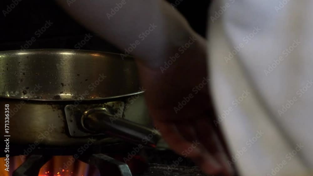 A kitchen worker prepares food at a restaurant. A kitchen worker prepares food at a restaurant.