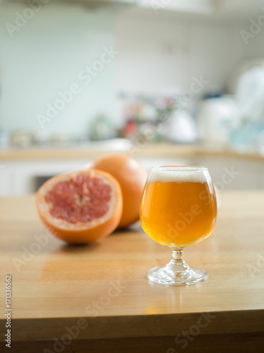 Juicy grapefruits and A glass of beer on wooden table 