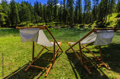 Pair of white chair on beach of relaxing lake at sunny day, Lago Ghedina
