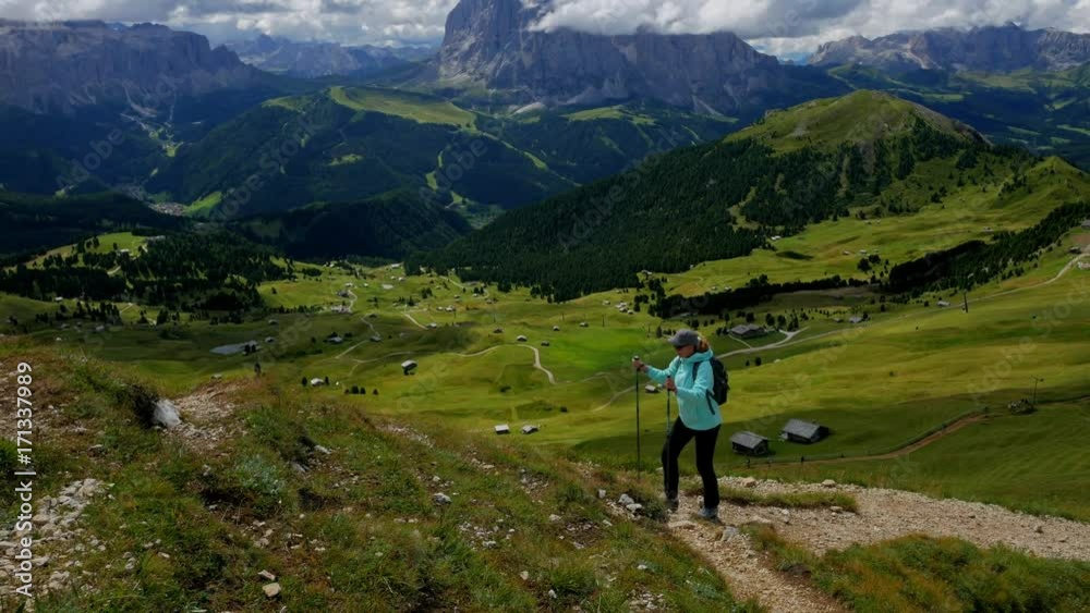 Hiker climbs along the path in beautiful highlands of Dolomites Hiker climbs along the path in beautiful highlands of Dolomites