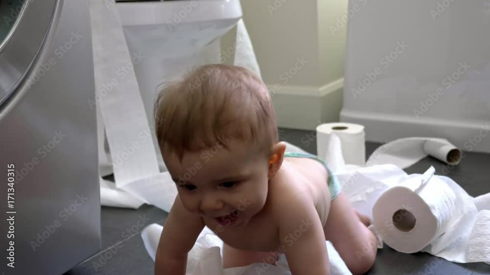 Toddler ripping up toilet paper in bathroom Toddler ripping up toilet paper in bathroom