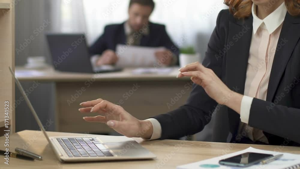 Busy female in black suit working on laptop and checking e-mail on smartphone Busy female in black suit working on laptop and checking e-mail on smartphone