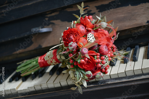 red-gold wedding bouquet stands on the piano