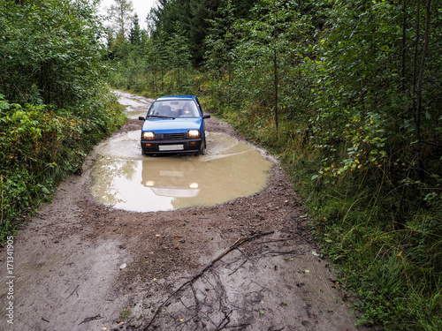 The car goes through the rain blurred the road. The car in the rain blurred the road. © sablinstanislav