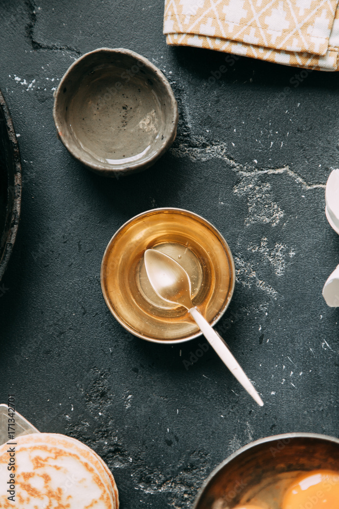 The process of cooking pancakes on a black background and set of ingredients The process of cooking pancakes on a black background and set of ingredients