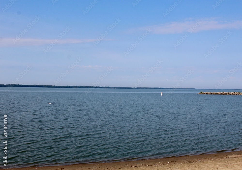 The view of the lake from the sand of the beach. The view of the lake from the sand of the beach.