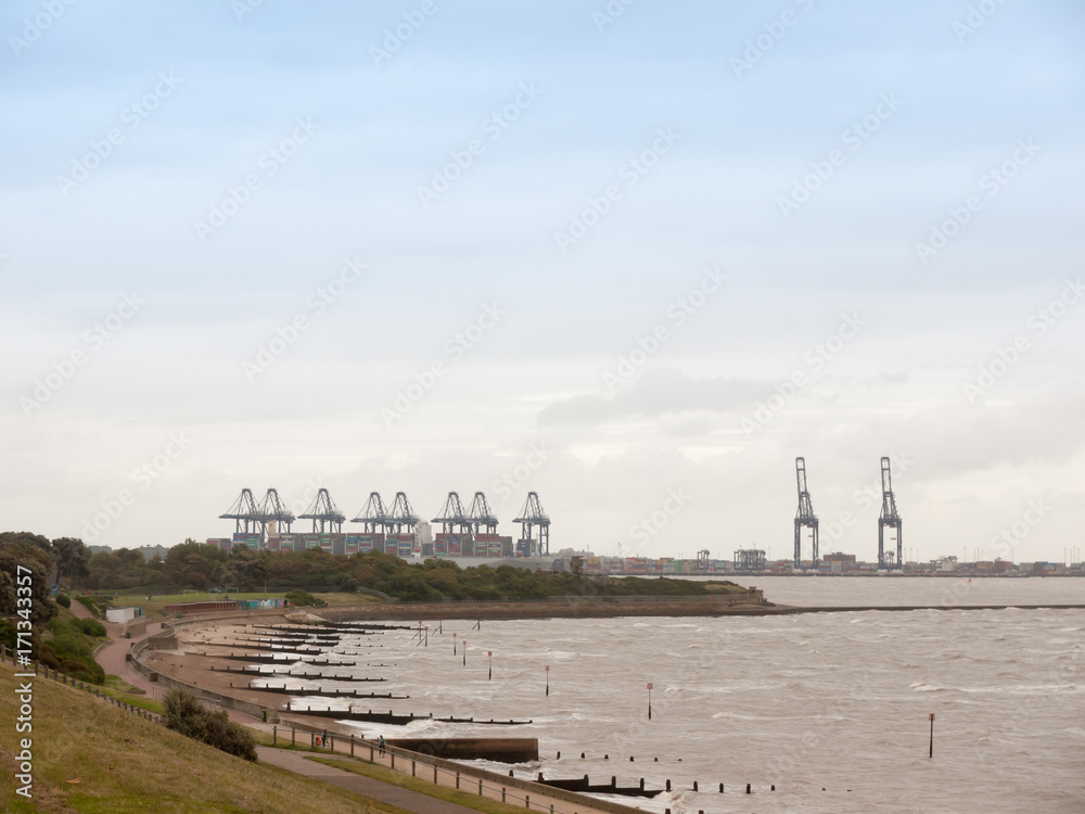 sea industry cargo and shipping cranes in the distance beach groynes Harwich Port sea industry cargo and shipping cranes in the distance beach groynes Harwich Port