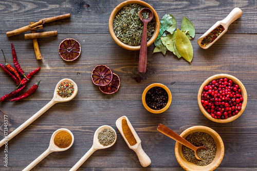 Colorful dry herbs and spices for cooking food wooden kitchen table background top view pattern