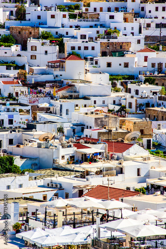 The view of the stunning Greek city Lindos with vibrant white houses and traditional local architecture. Greece trip to Rhodes island with its Mediterranean landscapes. .
