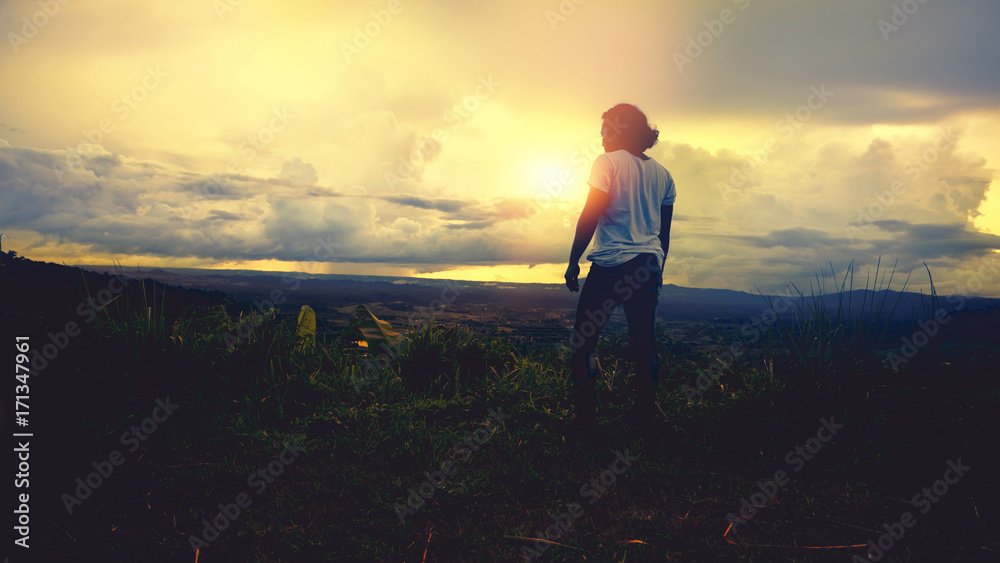 Asian man travel relax in the holiday. Stand looking at the sun on the mountain. Thailand Asian man travel relax in the holiday. Stand looking at the sun on the mountain. Thailand