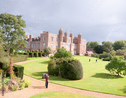 sunny overcast back garden view with people visiting long melford melford hall house manor