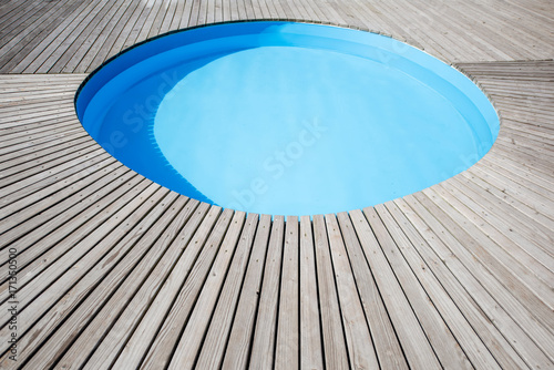 Round swimming pool with wooden poolside oudoors