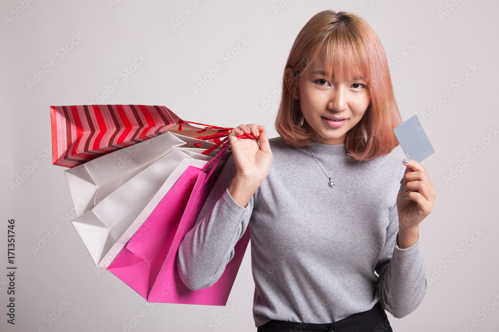 Young Asian woman with shopping bag and blank card. Young Asian woman with shopping bag and blank card.