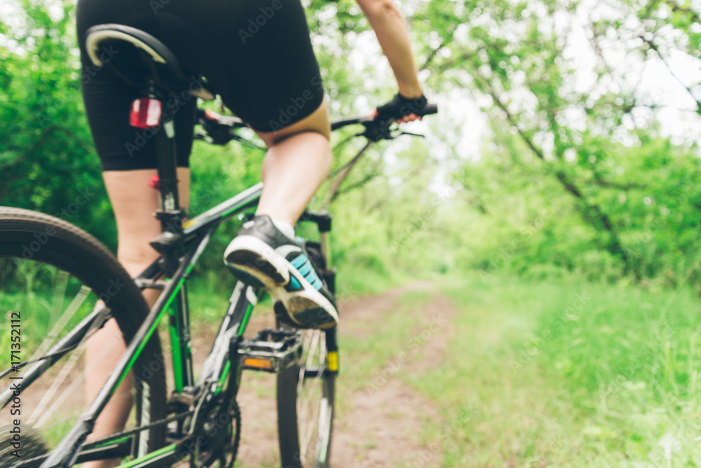 Woman riding a mountain bike in the forest Woman riding a mountain bike in the forest