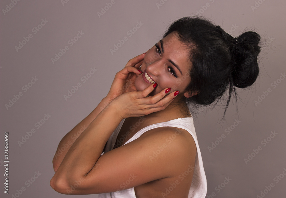 Fototapeta premium Close up portrait of brunette pretty woman with headache touching her face, look up. Beautiful woman stressed and worry in black sweater on light grey background. Health care and medicine.