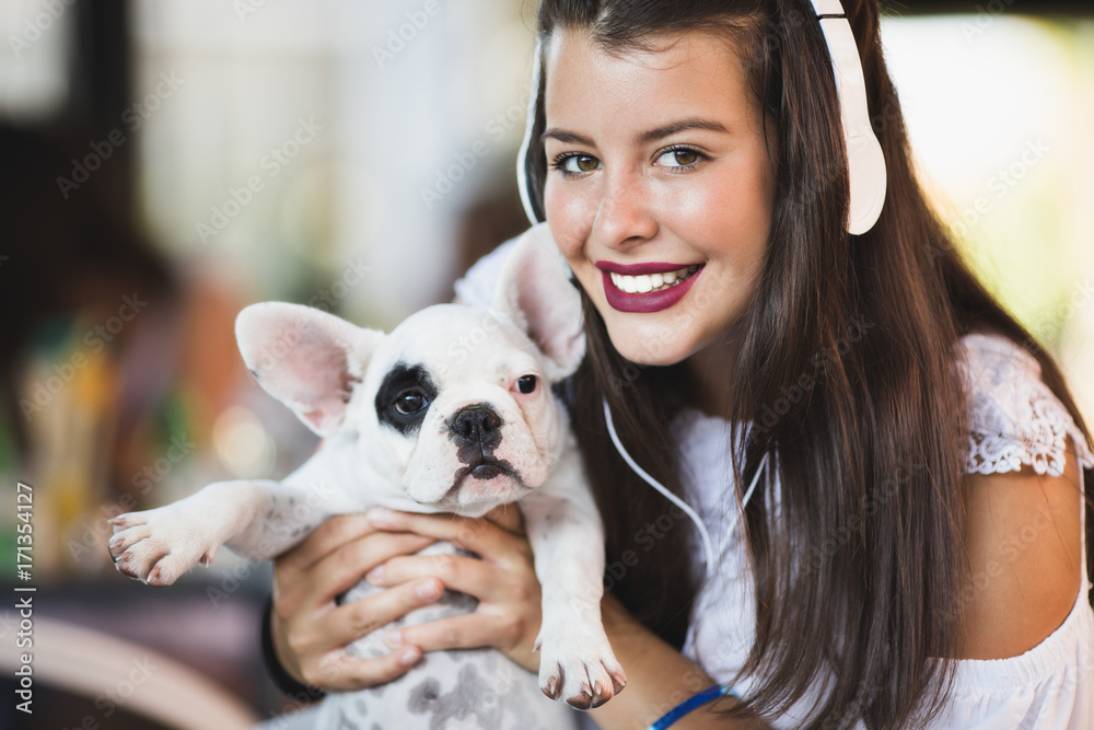 Beautiful young woman with sitting in cafe with her adorable French bulldog puppy. People with dogs theme. Beautiful young woman with sitting in cafe with her adorable French bulldog puppy. People with dogs theme.