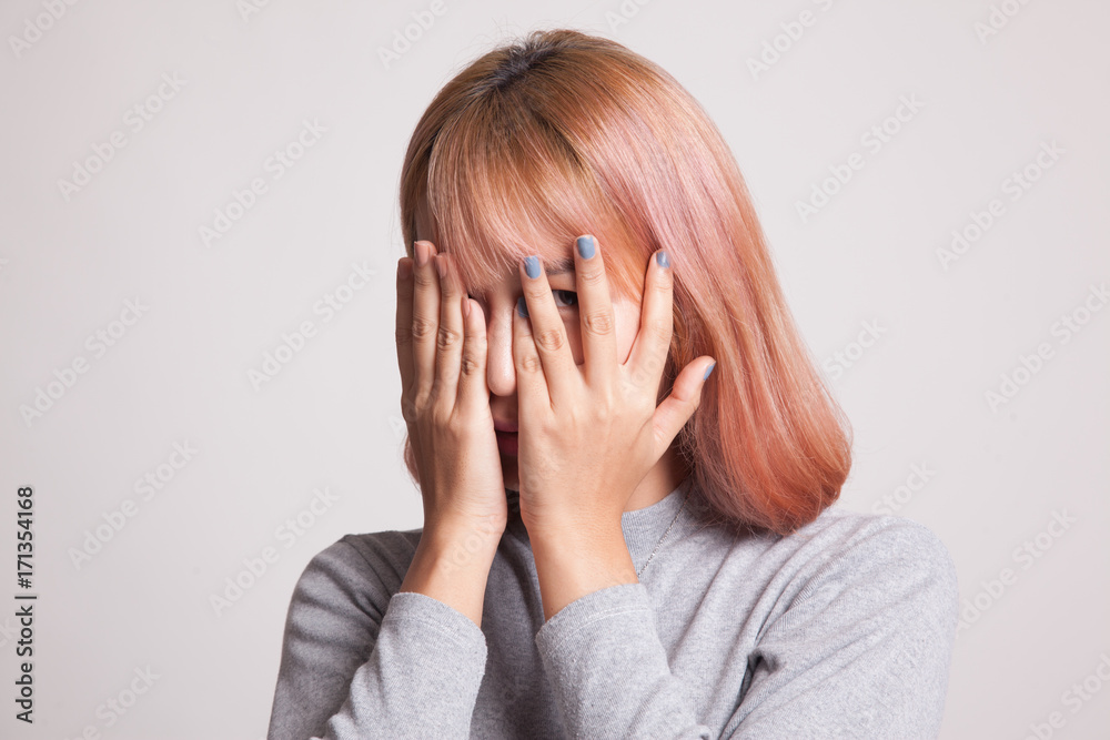 Beautiful young Asian woman peeking through fingers. Beautiful young Asian woman peeking through fingers.