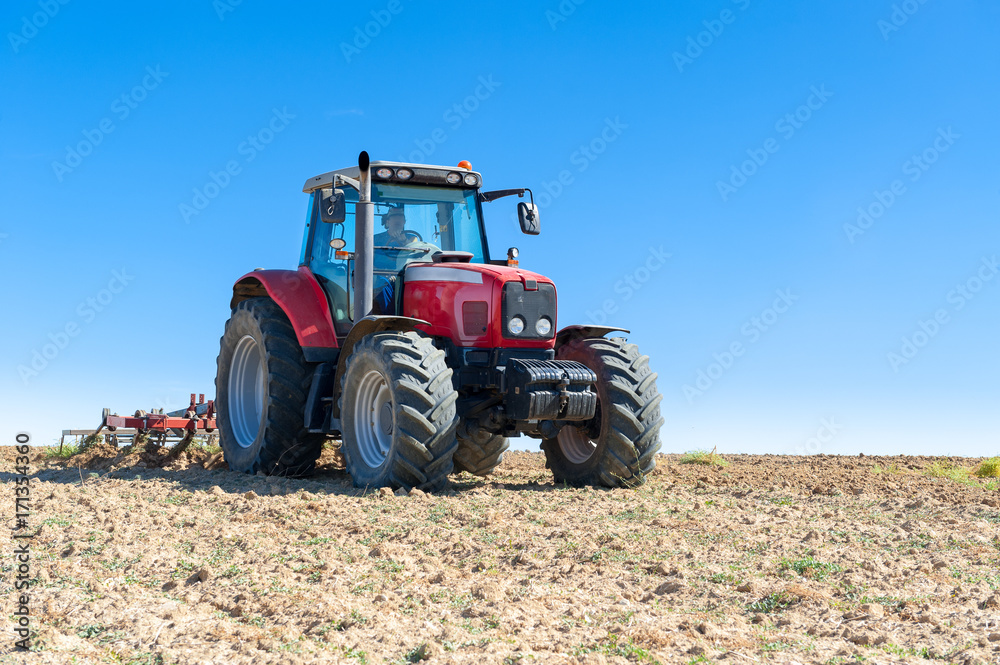 agricultural tractor in the foreground with blue sky background. agricultural tractor in the foreground with blue sky background.